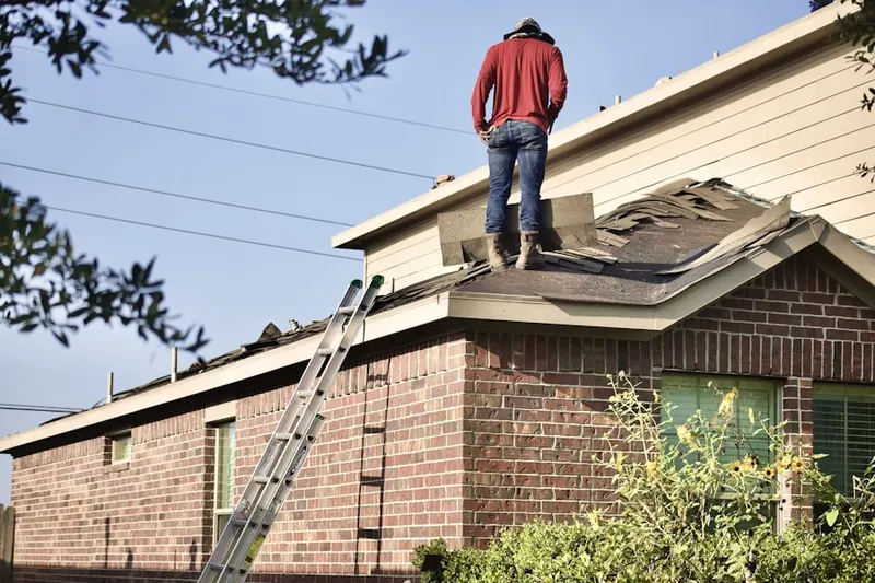 Professional roofer working on a residential roof in Granville